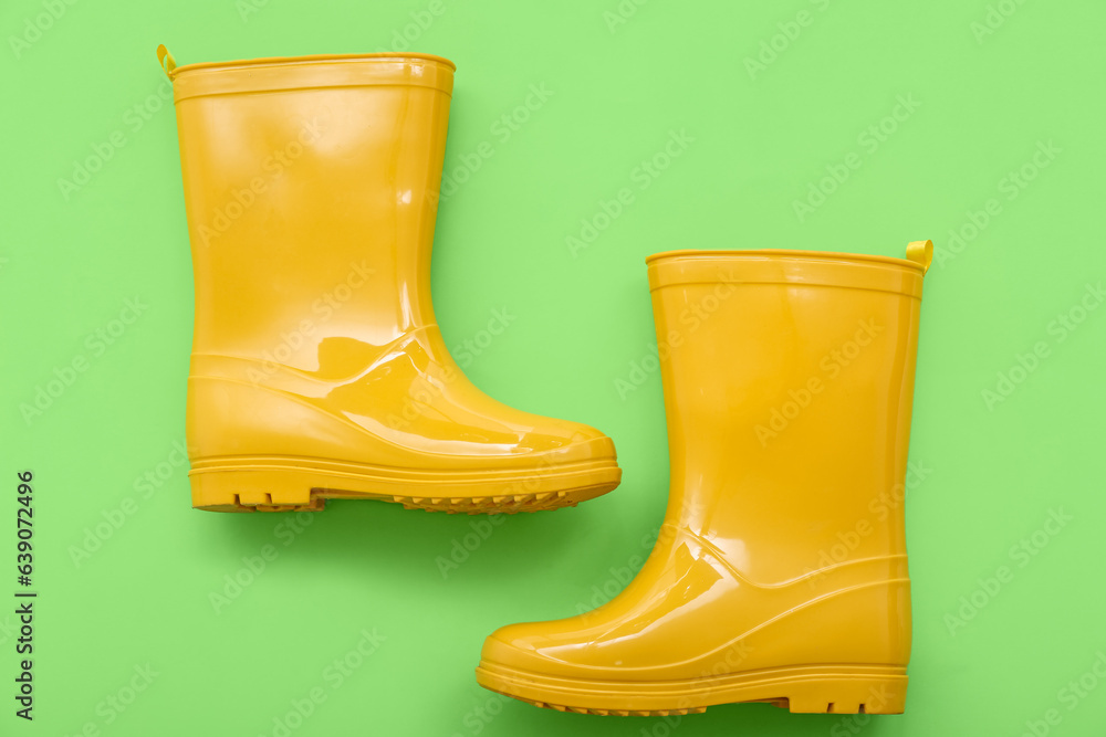 Yellow gumboots on green background