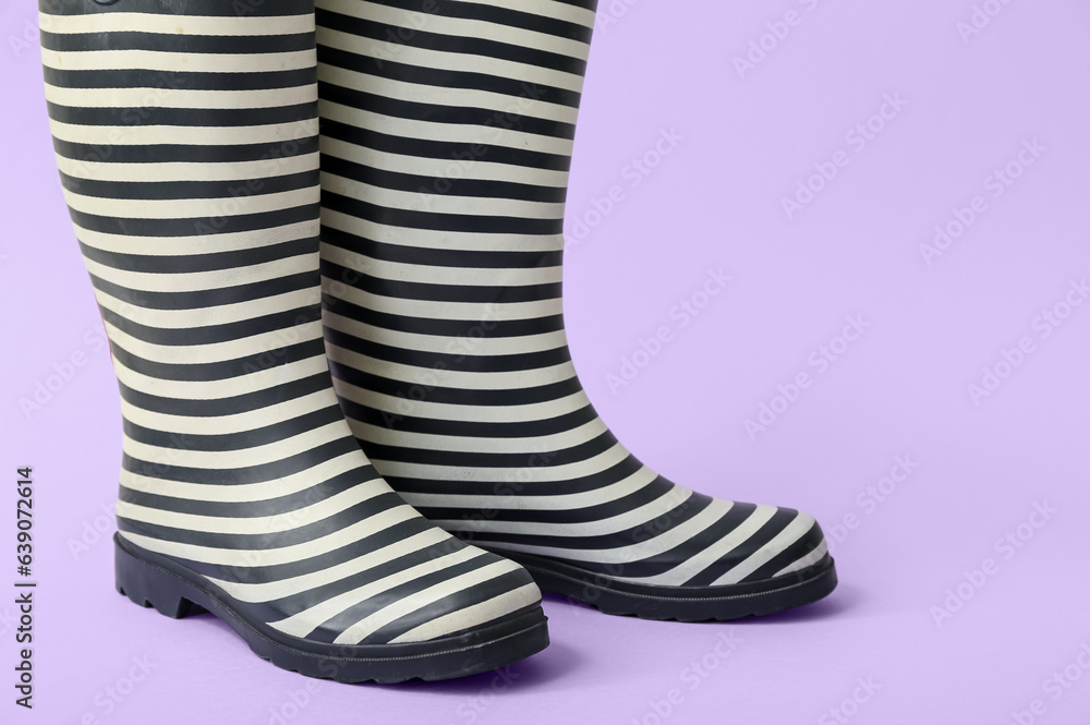 Stylish gumboots on lilac background