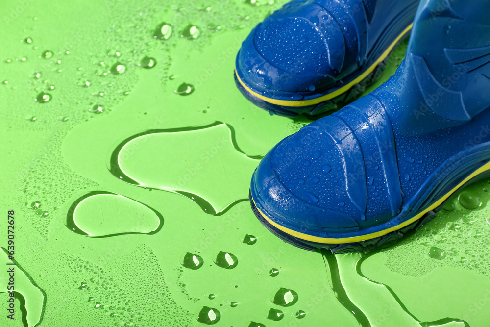 Blue gumboots in water on green background