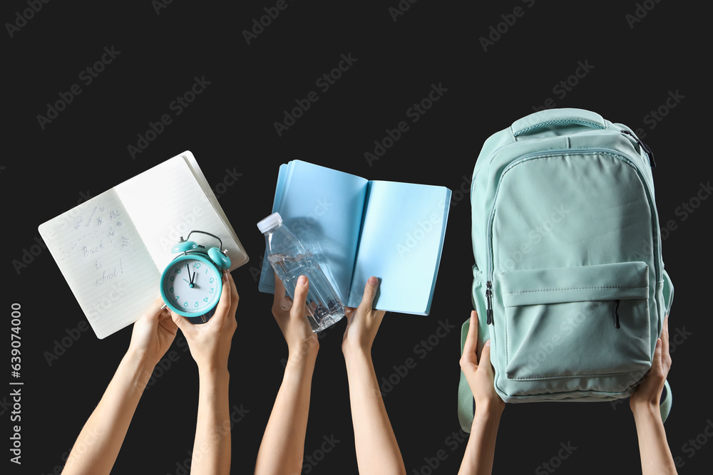 Female hands holding stationery, backpack and notebooks with text BACK TO SCHOOL on black background