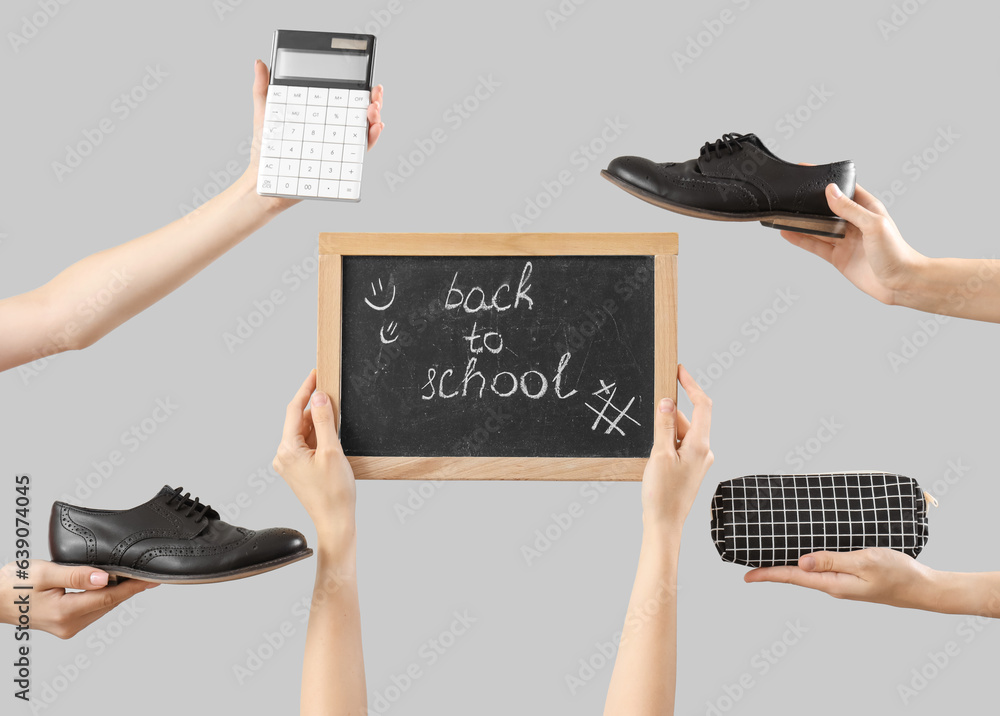 Female hands holding stationery, school shoes and blackboard with text BACK TO SCHOOL on grey backgr