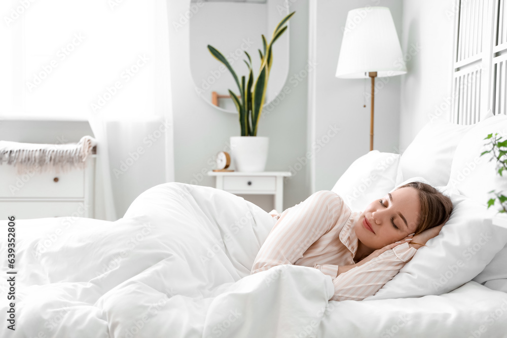 Young woman sleeping in bed at home