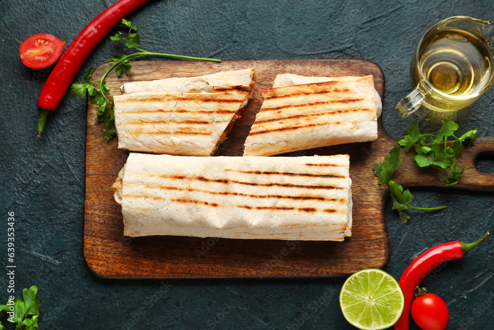 Wooden board with tasty shawarma and parsley on dark background