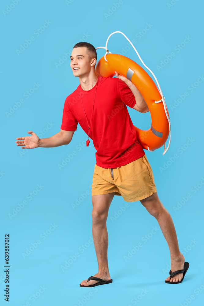 Male lifeguard with ring buoy on blue background