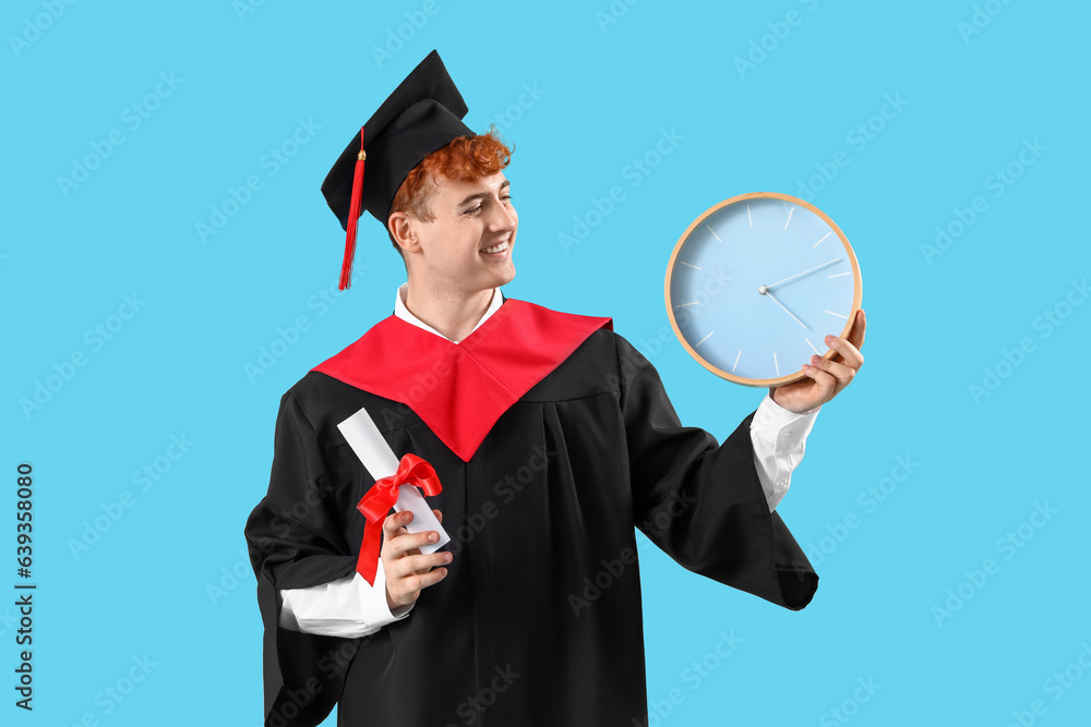 Male graduate student with diploma and clock on blue background