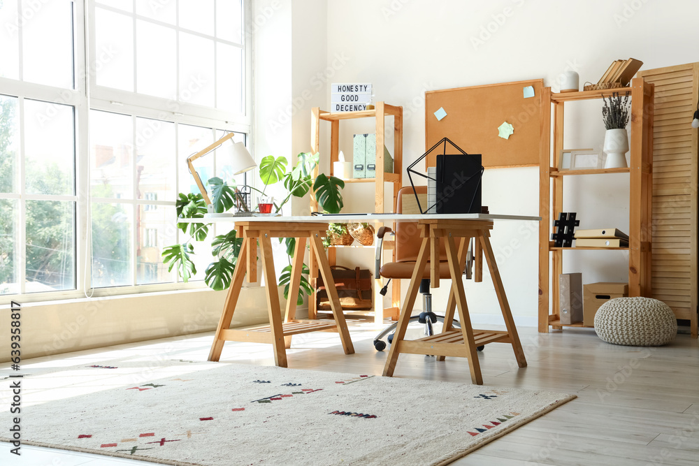 Interior of light office with workplace and shelving units