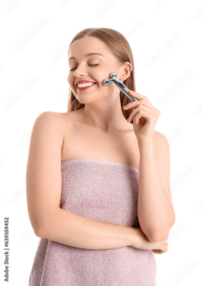 Pretty young woman with facial massage roller on white background