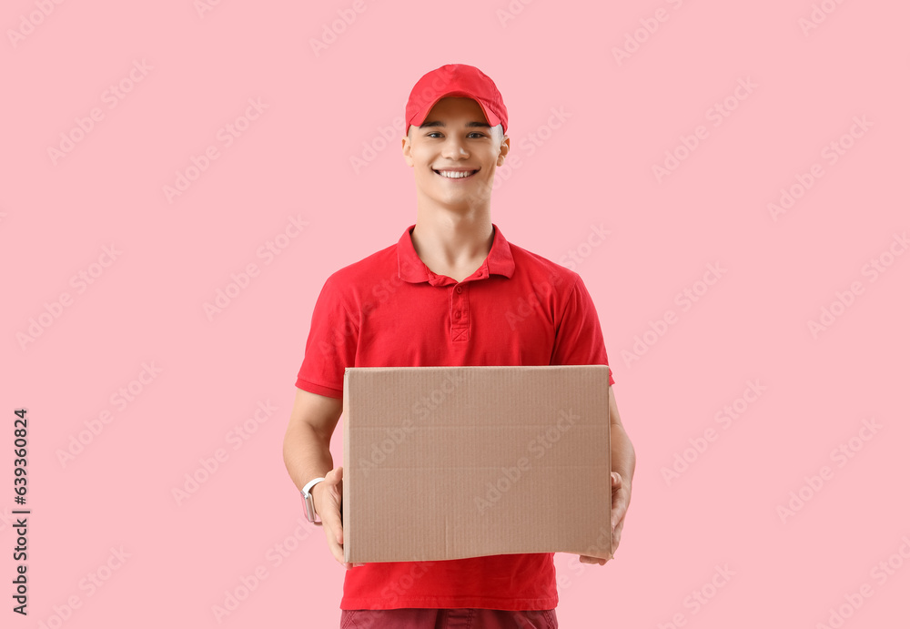 Young courier with parcel on pink background