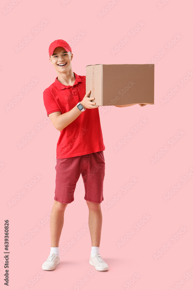 Young courier with parcel on pink background