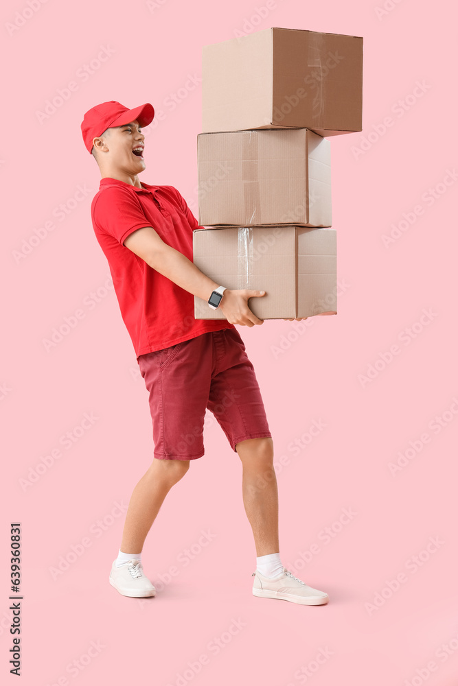 Young courier with parcels on pink background