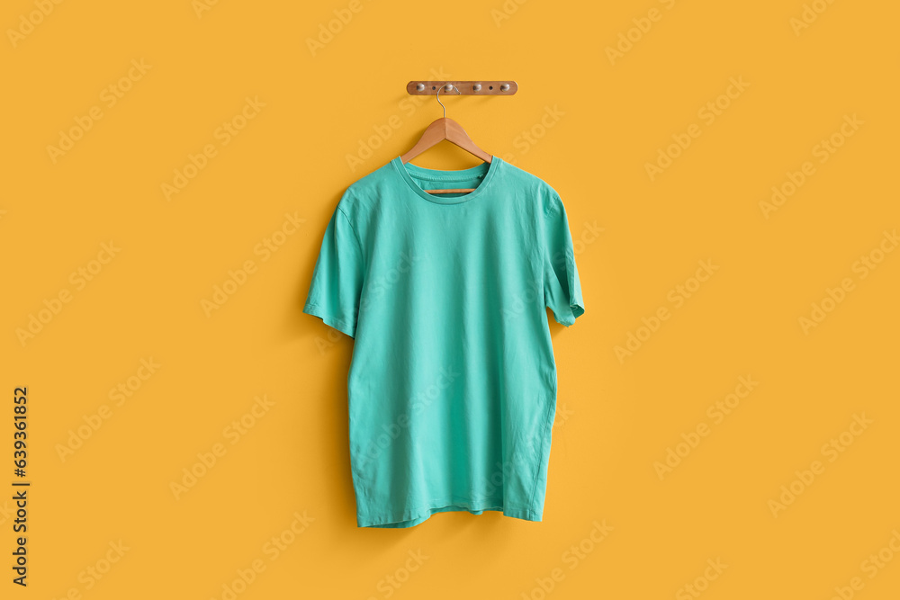 Stylish blue t-shirt hanging on yellow background