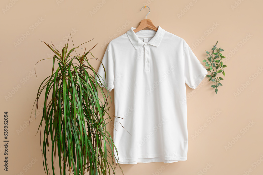 Stylish white t-shirt hanging on beige background