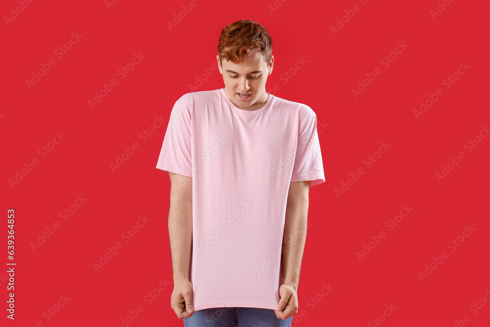 Young man in t-shirt on red background