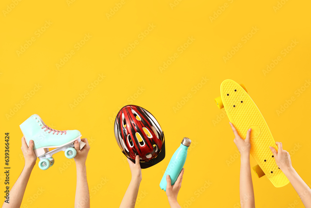 Female hands different sports equipment on orange background