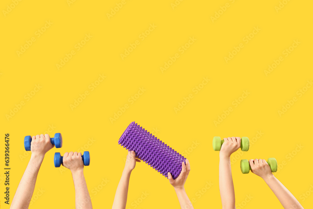 Female hands different sports equipment on orange background