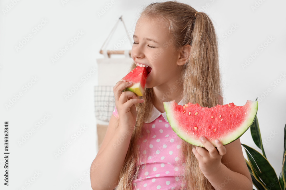 Little girl eating fresh watermelon in kitchen