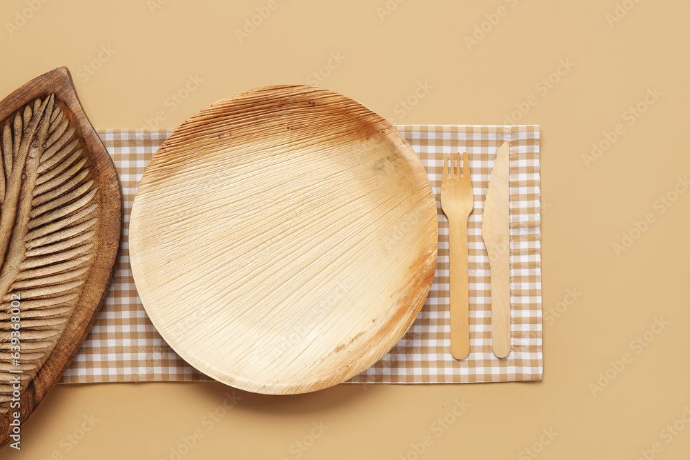 Wooden plate, board and cutlery on beige background