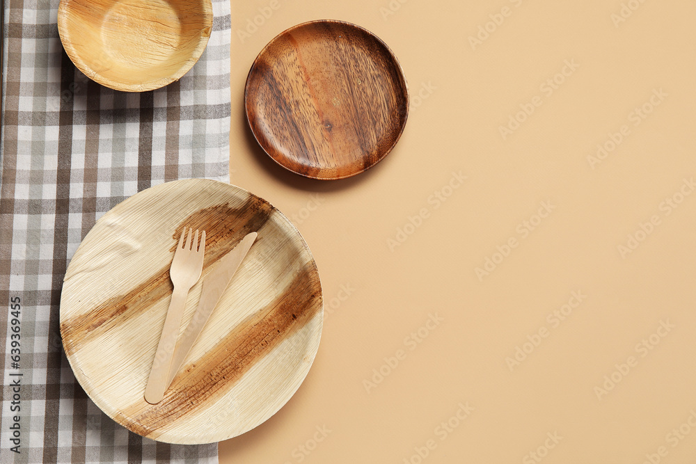 Wooden plates and cutlery on beige background