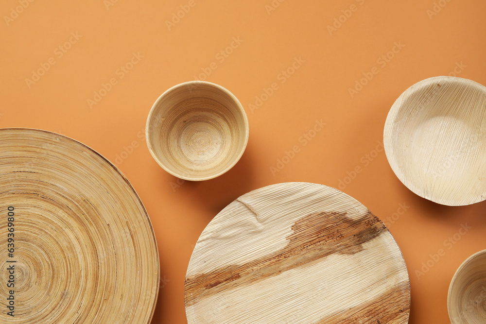 Wooden plates and bowls on beige background