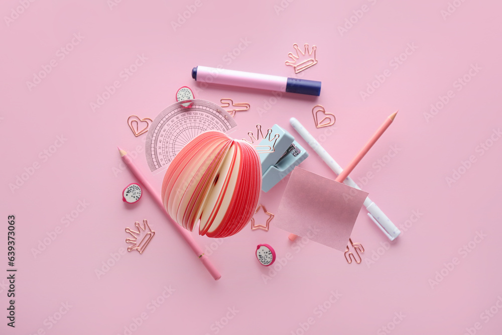 Different flying stationery on pink background