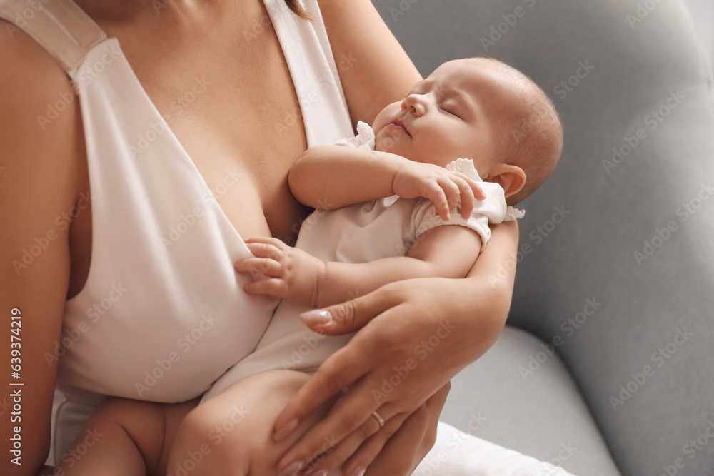 Young woman with her baby sitting in armchair at home, closeup