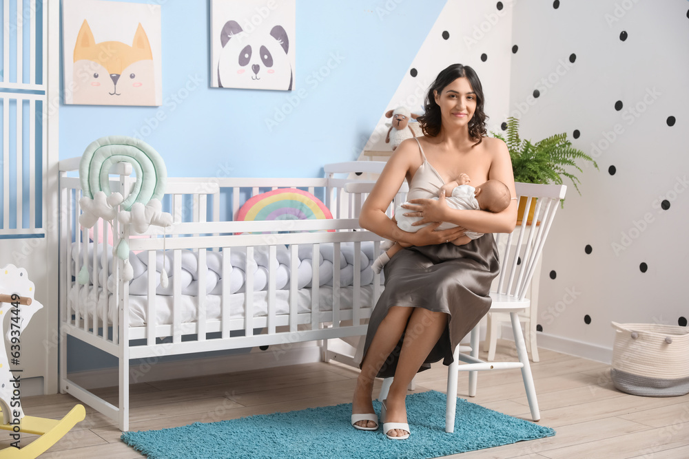 Young woman breastfeeding her baby in bedroom