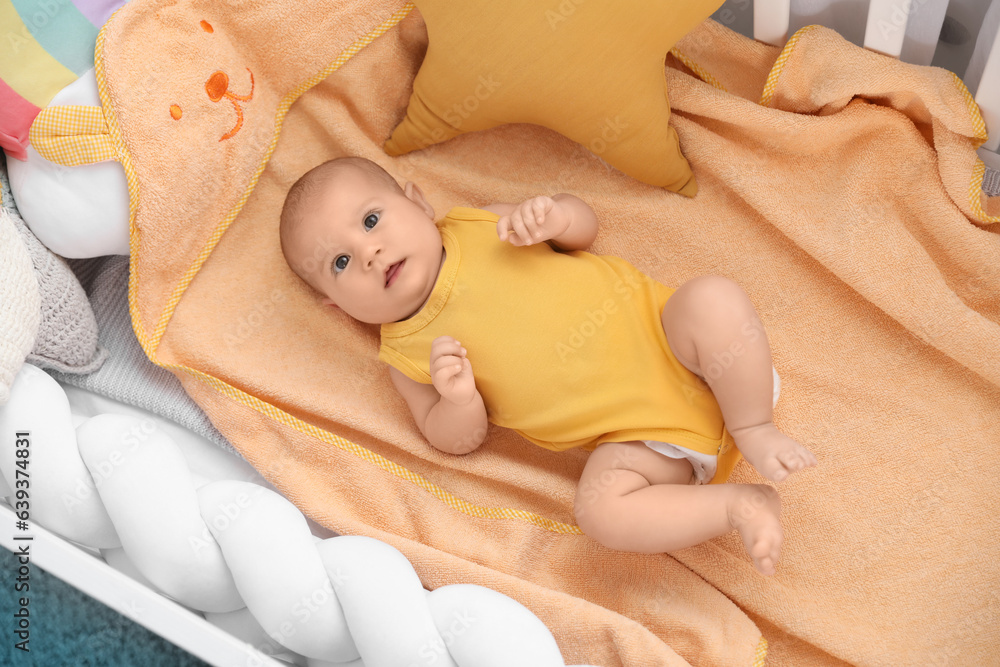 Cute baby lying in crib, top view