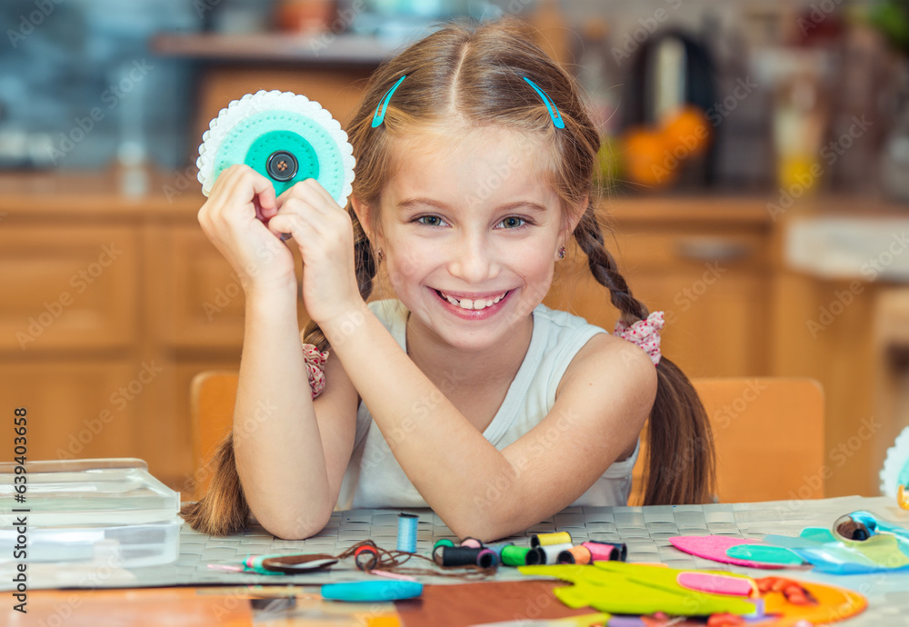 happy cute little girl shows materials for needlework