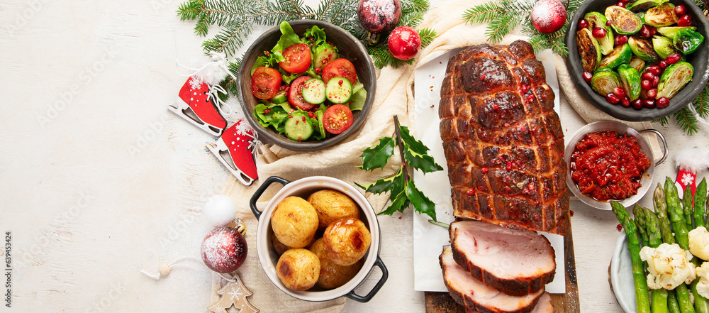 Delicious Christmas themed dinner table with roasted meat, appetizers and desserts. Holiday concept.