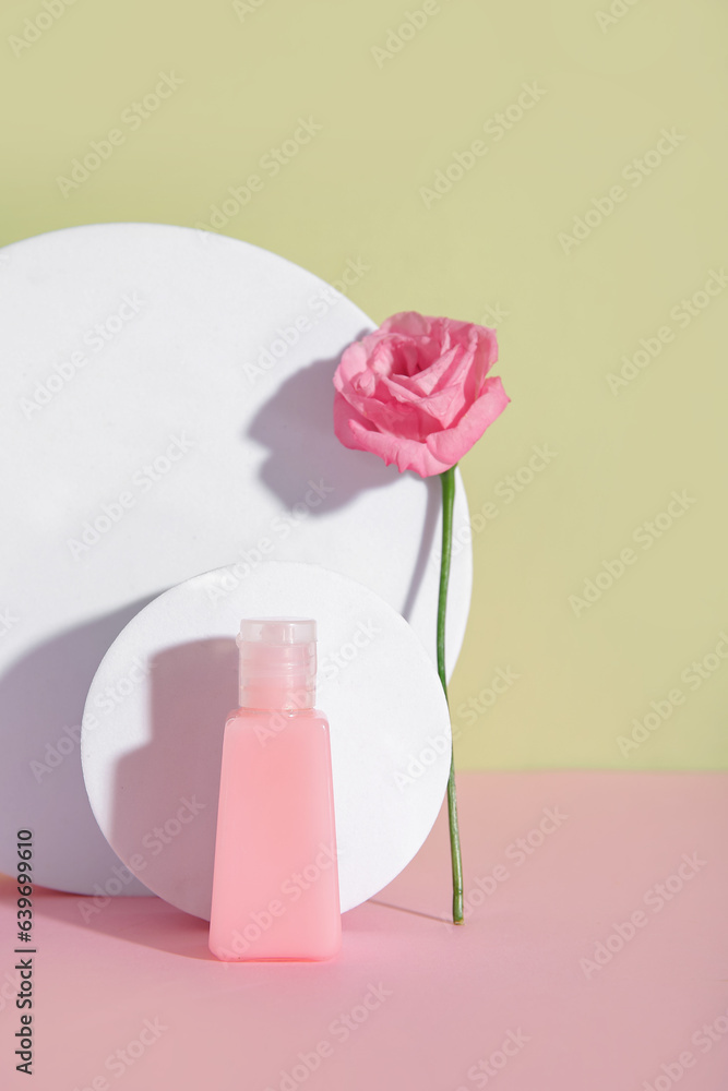 Composition with bottle of cosmetic product, plaster podiums and rose flower on color background