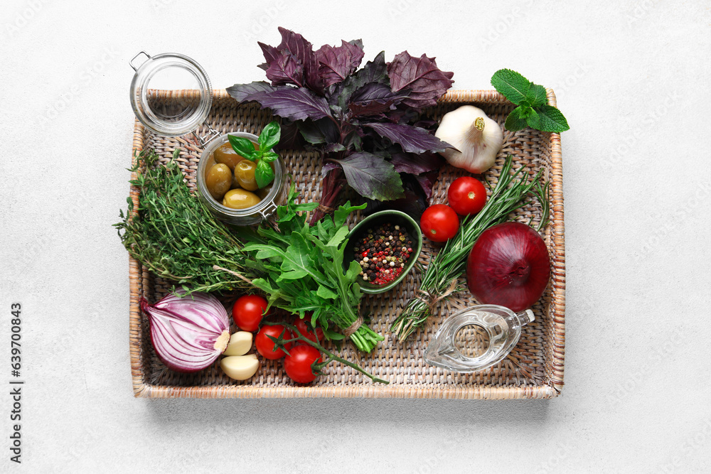 Tray with herbs, spices and vegetables on light background