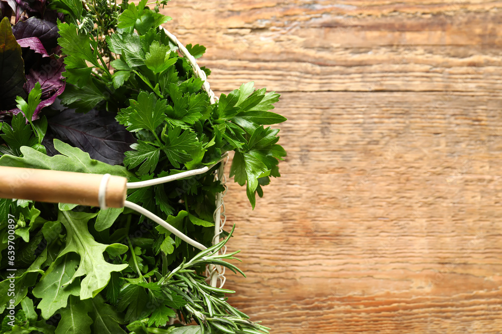 Basket with fresh herbs on wooden background, closeup