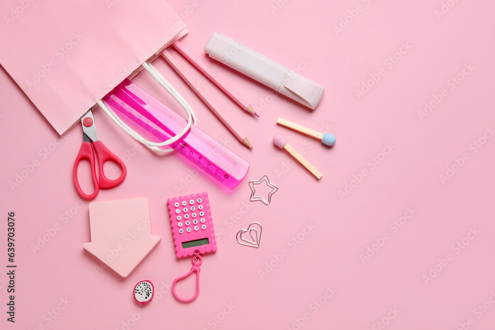 Composition with paper bag and different stationery on pink background