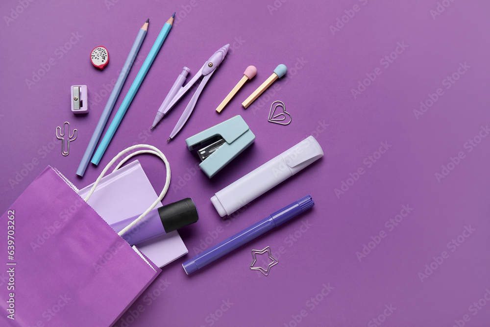 Composition with paper bag and different stationery on purple background