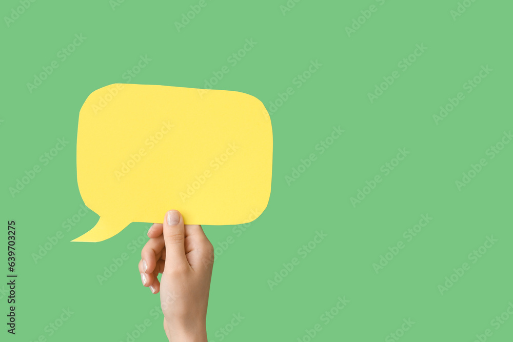 Female hand with speech bubble on green background