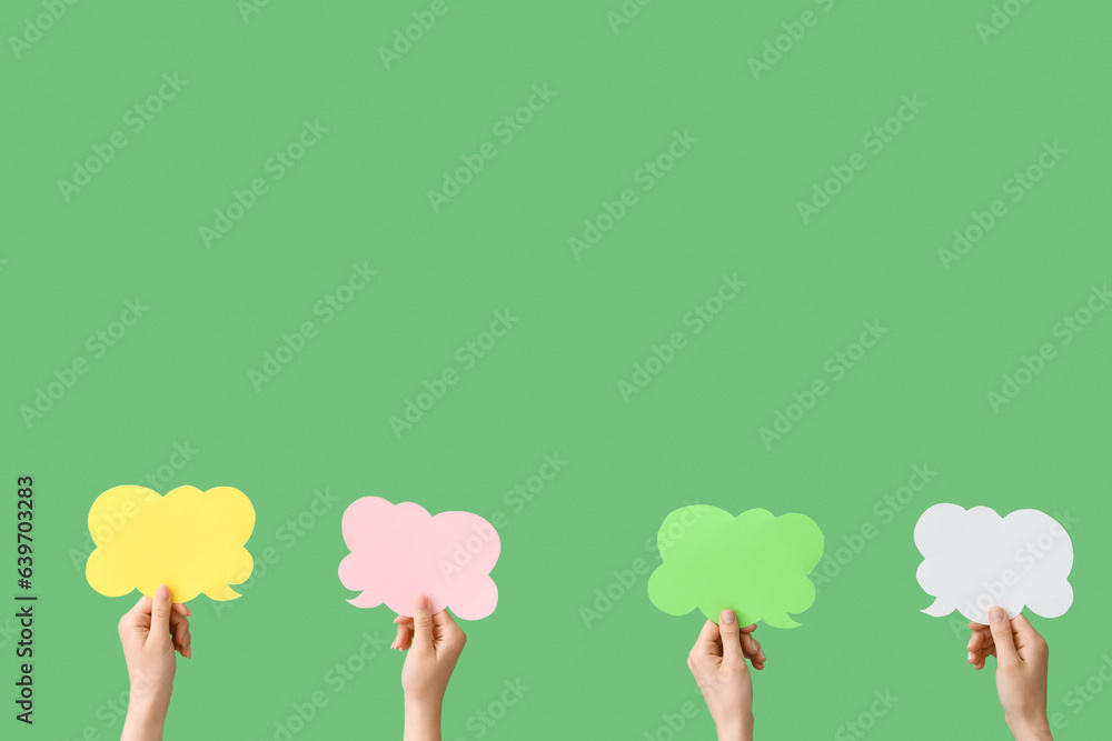 Female hands with speech bubbles on green background