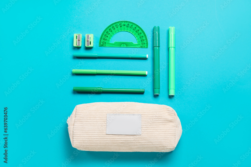 Pencil case and school stationery on turquoise background