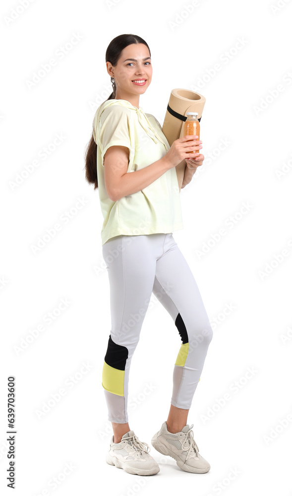 Sporty young woman with healthy smoothie and fitness mat on white background