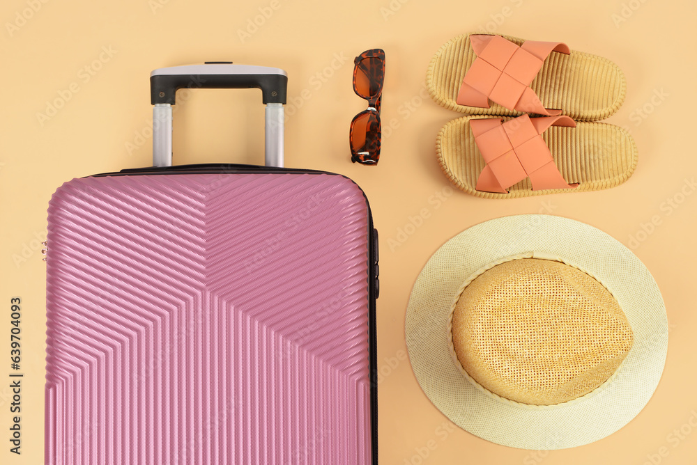 Stylish hat, shoes, sunglasses and suitcase on color background