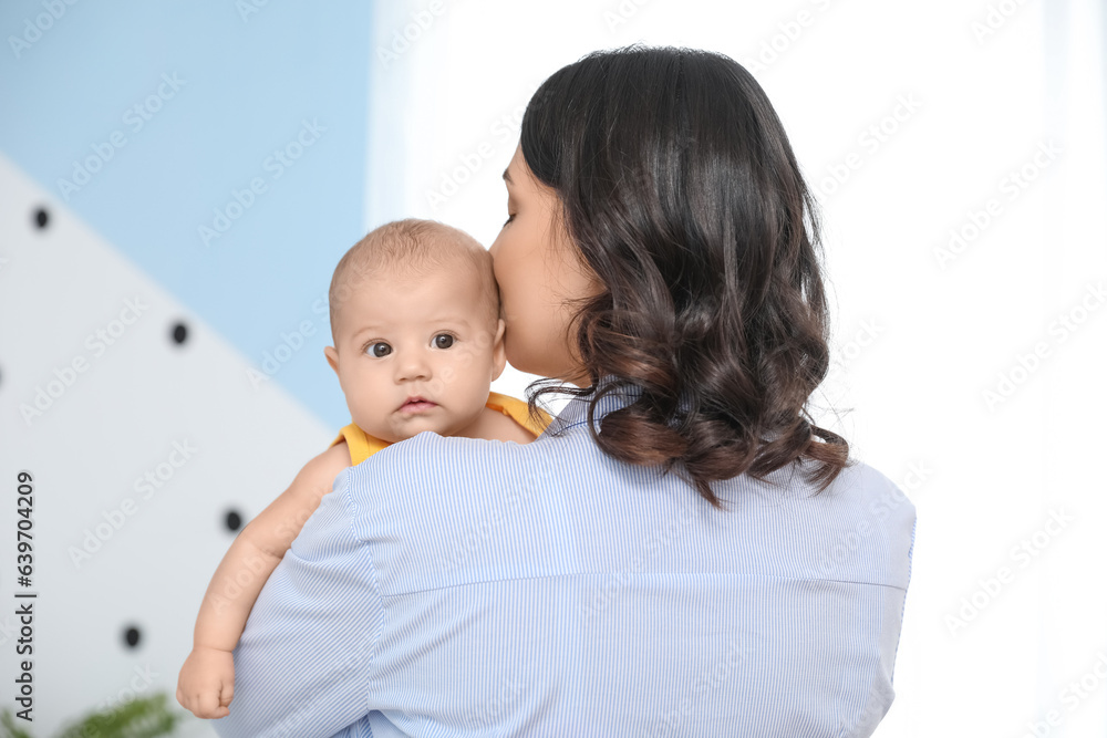 Young woman with her baby in bedroom