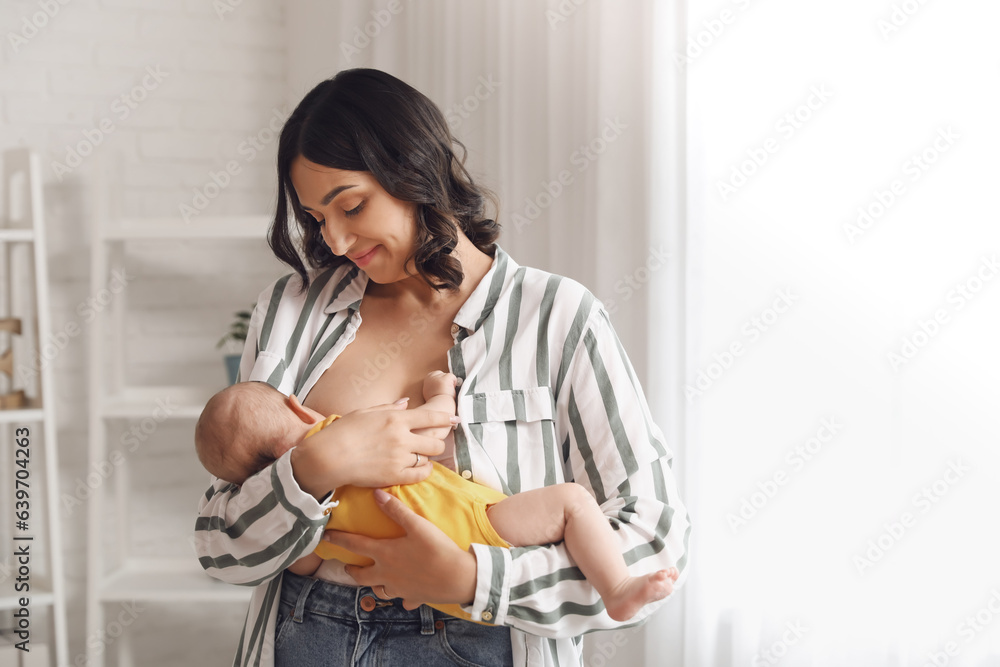 Young woman breastfeeding her baby at home