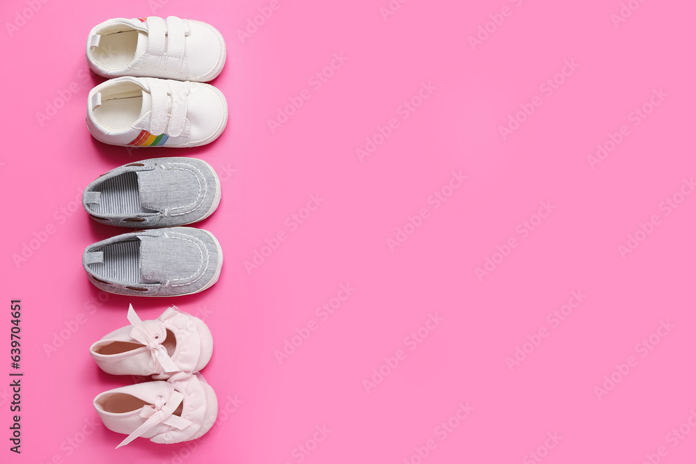 Set of stylish baby booties on pink background