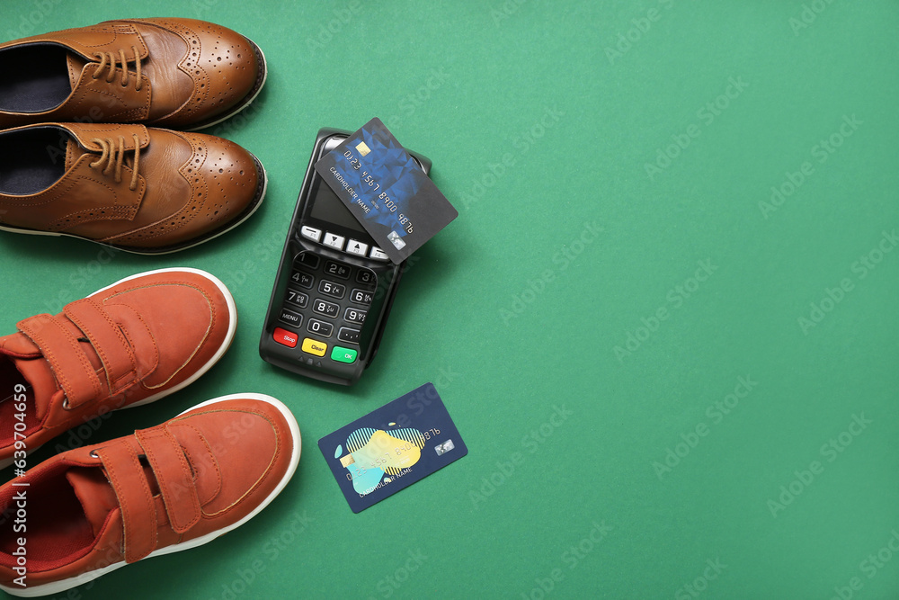 Stylish childs shoes, payment terminal and credit cards on green background