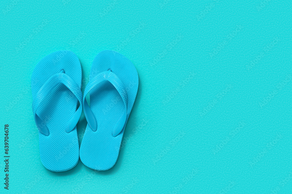 Pair of childs flip-flops on color background