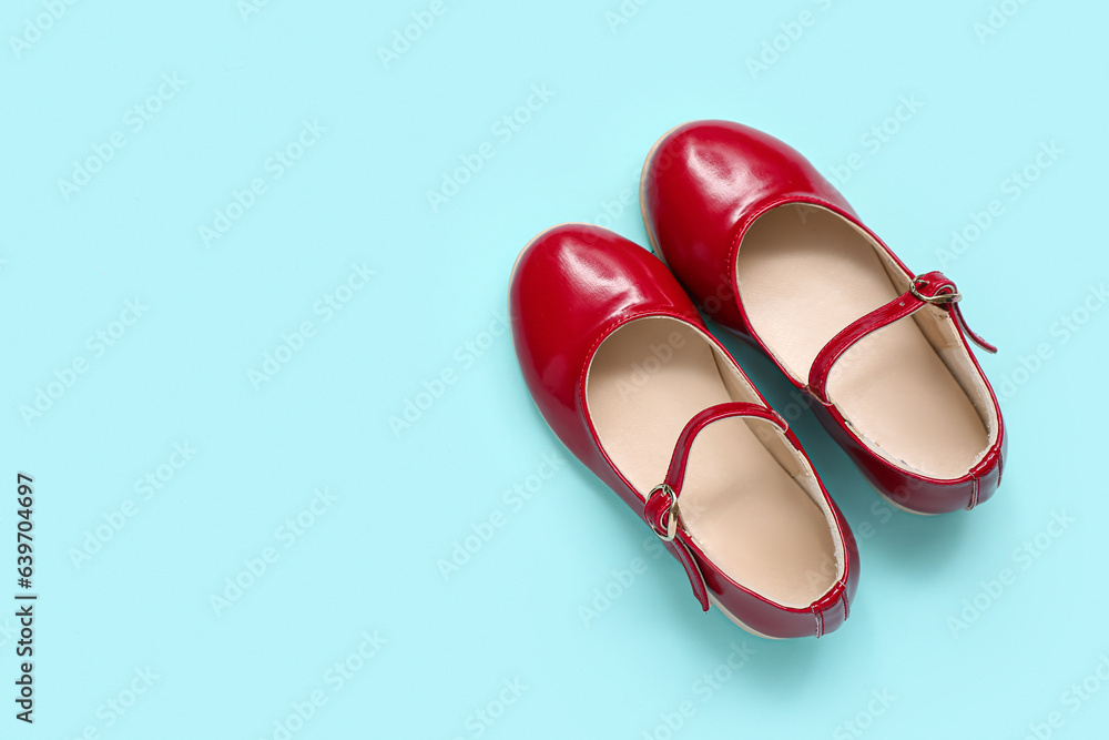 Pair of red childs shoes on color background