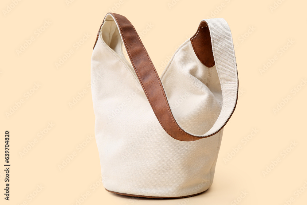 Stylish white handbag on beige background