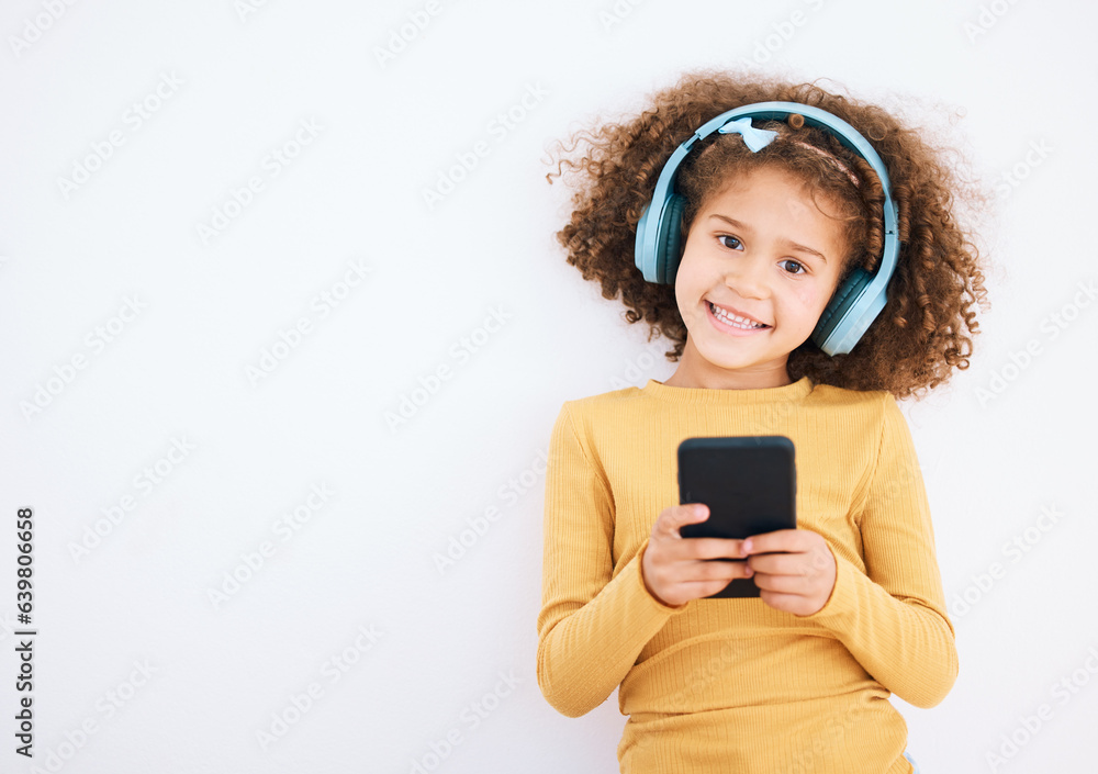 Girl child, portrait and smartphone, headphones and music with smile isolated on white background. T