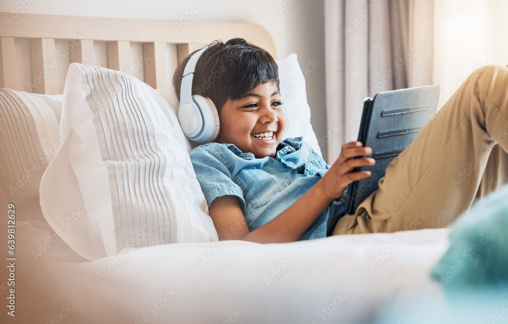 Child, tablet and smile with headphones on bed for online games, watch movies or play educational ap