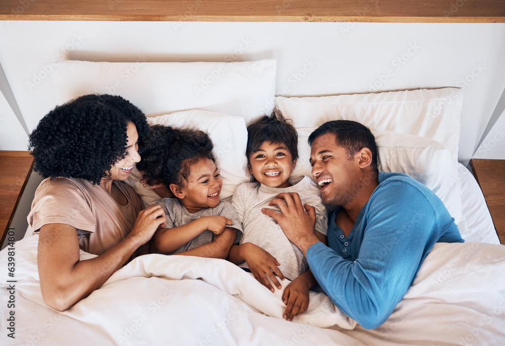 Family, funny and kids laughing in bed at home in the morning together with their happy parents. Rel