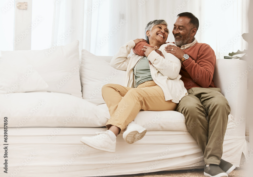 Happy, laugh and senior couple hug on sofa with conversation, care and romance in their home. Smile,